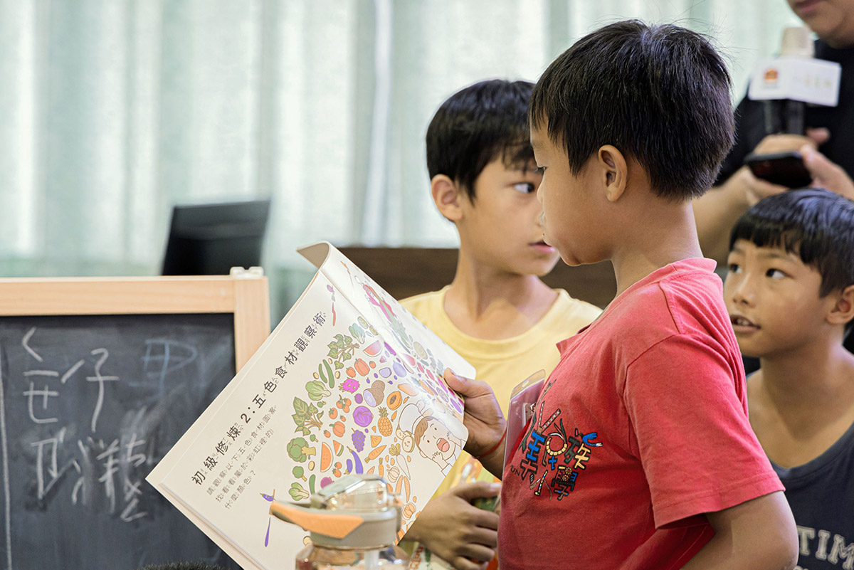 右圖：博幼學童利用營養魔法師作業本學習基本營養知識